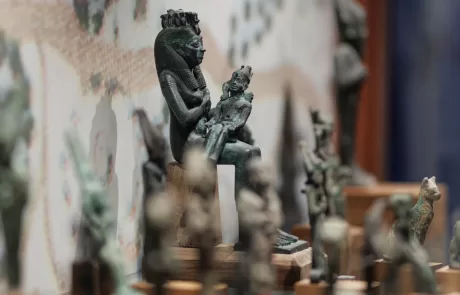 MAEC Cortona collezione egizia. Scultura in bronzo di Iside seduta con Horus sulle ginocchia, in atto di allattarlo, su base trapezoidale.